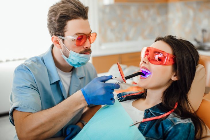 dentist using dental tool to check tooth sensitivity after filling